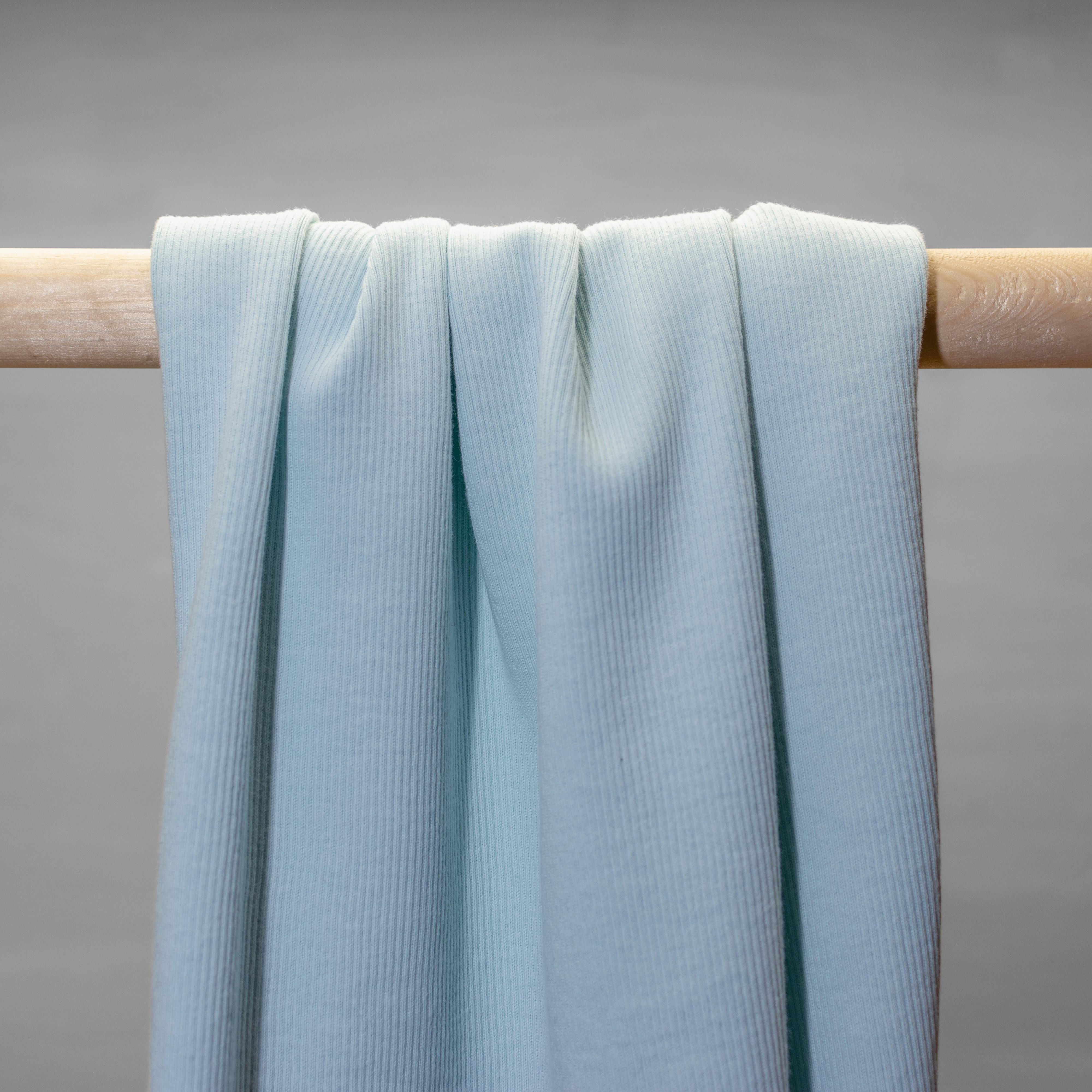Powder blue rib knit jersey hanging in folds.